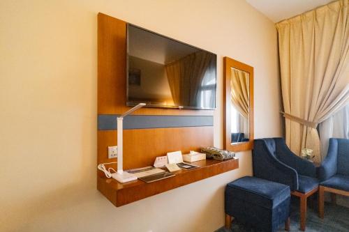 a room with a desk and a chair and a mirror at Emaar Elite Al Madina Hotel in Al Madinah