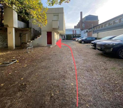 a parking lot with a red arrow in front of a building at Jean Paul 2 Au cœur de Rouen , gare "Ménage & Linge Inclus" in Rouen