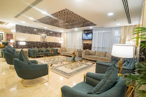 a lobby with couches and chairs and a television at Emaar Elite Al Madina Hotel in Al Madinah