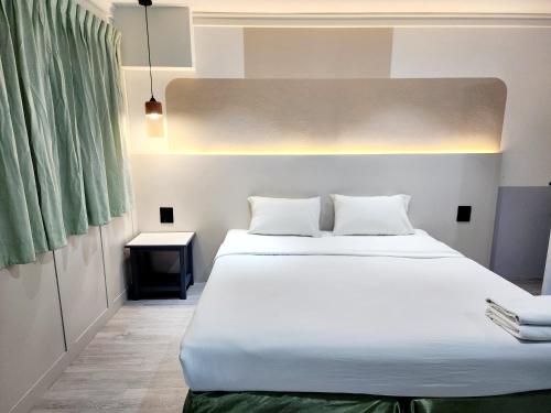 a bedroom with a large white bed in a room at SEATEL Phuket, Patong Beach in Patong Beach