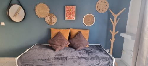 - une chambre avec un lit avec des oreillers et un mur bleu dans l'établissement La Maison de la Gardiole, à Frontignan