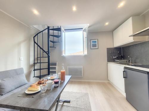une cuisine avec une table avec de la nourriture dessus dans l'établissement Nestor&Jeeves - VIEUX NICE DUPLEX - Studio - Central, à Nice
