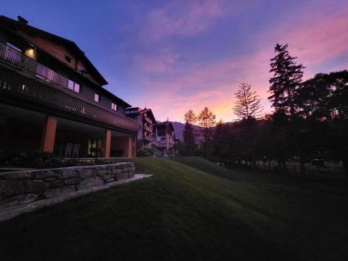 a sunset view of a house and a yard at K2 home in Bormio