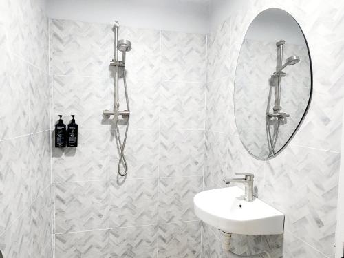 a white bathroom with a sink and a mirror at SEATEL Phuket, Patong Beach in Patong Beach