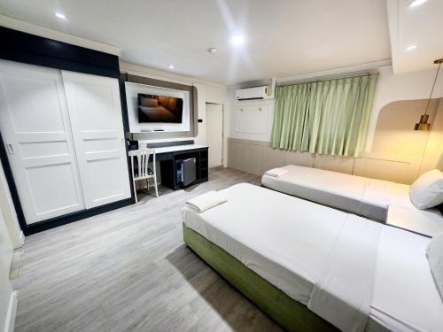 a hotel room with two beds and a tv at SEATEL Phuket, Patong Beach in Patong Beach