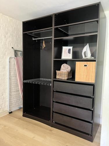 a black book shelf with some items in it at Rez-de-jardin proche Lille in Marcq-en-Baroeul