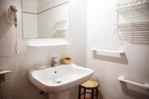a white bathroom with a sink and a mirror at Bio Agriturismo Poggio Aione in Saturnia