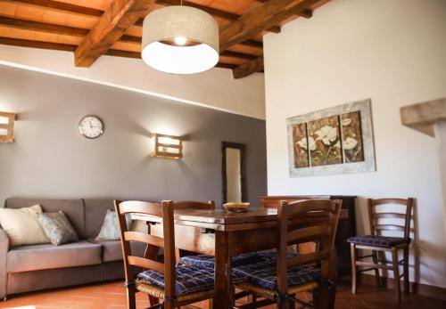 a living room with a table and chairs and a couch at Bio Agriturismo Poggio Aione in Saturnia