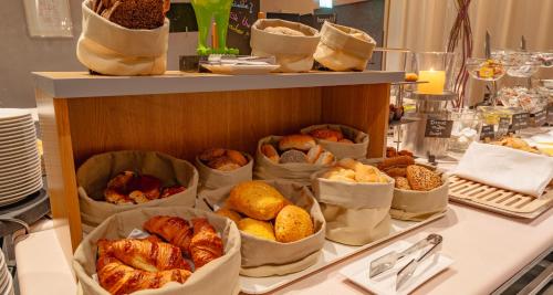 a buffet with many different types of breads and pastries at PLAZA Premium Grand Winston in Rijswijk
