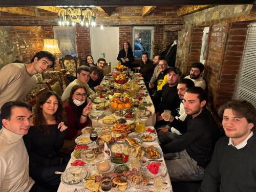 a group of people sitting around a long table of food at city point in Kutaisi