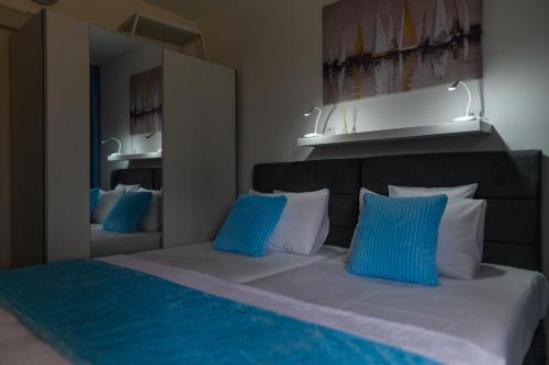 a bedroom with a bed with blue and white pillows at SPA apartman Tomin adults only in Soko Banja