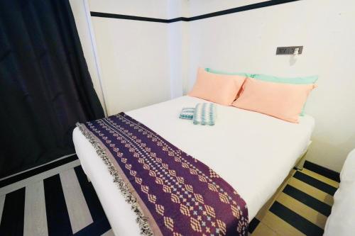 a small bed with pillows and a blanket on it at The Locals Bangkok Old Town in Bangkok