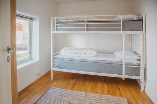 Un dormitorio con dos literas y una ventana. en Sjøgata Apartment, en Kabelvåg