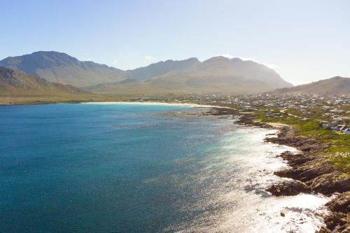 a view of a beach with mountains in the background at Secure, luxurious with lovely views in Pringle Bay