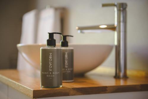 two bottles of soap sitting on a counter in a bathroom at Secure, luxurious with lovely views in Pringle Bay