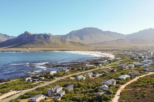 an aerial view of a beach with houses and mountains at Secure, luxurious with lovely views in Pringle Bay