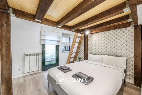 ein Schlafzimmer mit einem großen Bett und einer Leiter in der Unterkunft MyHouseSpain - Great apartment 6 PAX MADRID CITY CENTER in Madrid
