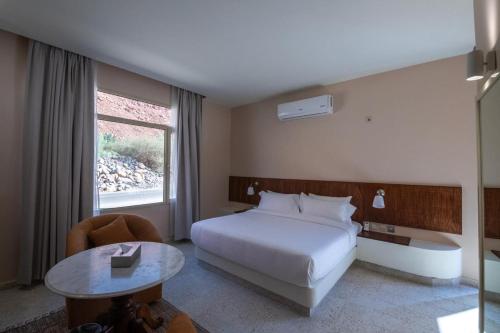 a hotel room with a bed and a table at Wadi Sader in AlUla