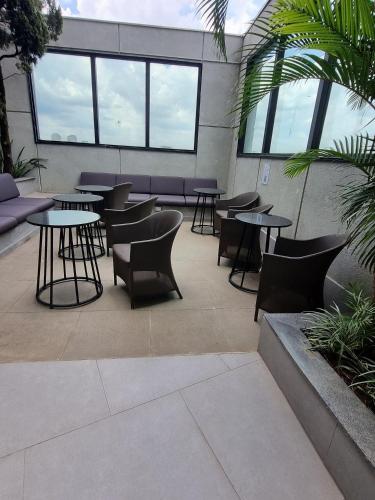 a patio with tables and chairs in a building at Morada Supreme Flat Jardim Europa II in Sao Paulo