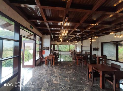 een eetkamer met tafels en stoelen en ramen bij Cloud Paradise Resort in Lao Cai