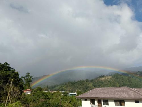 a rainbow in the sky over a house at Hostal Vista Boquete in Bajo Boquete