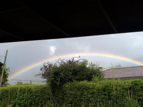 a rainbow in the sky over a house at Hostal Vista Boquete in Bajo Boquete