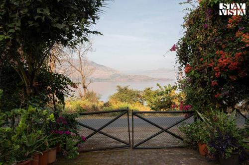 a gate with flowers and a view of the water at StayVista at Laguna Escape with Deck, Pool, Bathtub in Wai