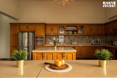 a kitchen with wooden cabinets and a table with oranges on it at StayVista at Laguna Escape with Deck, Pool, Bathtub in Wai
