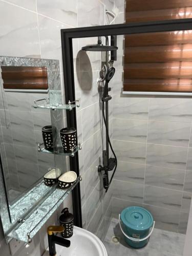 a bathroom with a shower with a sink and a mirror at Saceaas homes in Accra