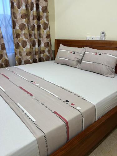 a bed with white sheets and pillows on it at Saceaas homes in Accra