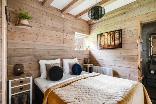 a bedroom with a bed in a wooden wall at Boerenlodge 't Vennetje in Fluitenberg