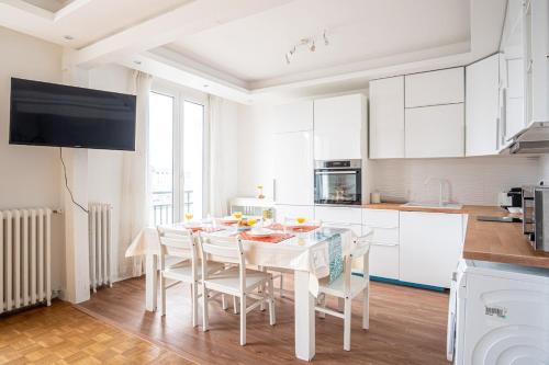 - une cuisine avec une table et des chaises blanches dans la chambre dans l'établissement La Passerelle - Petit Balcon, au Havre