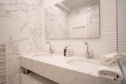 une salle de bain blanche avec un lavabo et un miroir dans l'établissement La Passerelle - Petit Balcon, au Havre