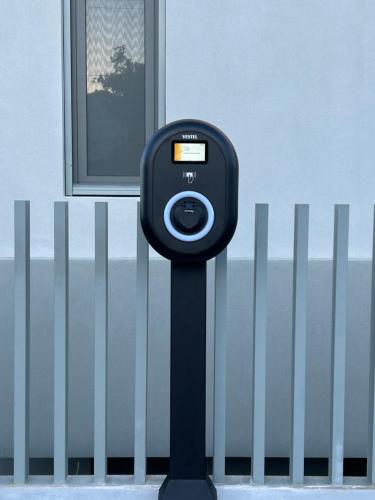 a black parking meter next to a fence at Heliades Residence in Kounoupidhianá