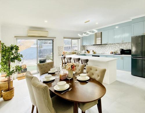a kitchen and dining room with a table and chairs at Modern Family Oasis - 4BR, Free Parking, Steps to Shops & Train in Melbourne