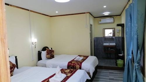 a hotel room with two beds and a mirror at ShuYa Hotel 舒雅酒店 in Luang Prabang