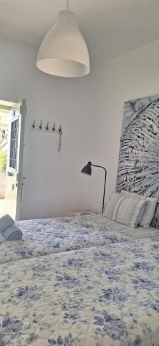 a bedroom with a bed with a blue and white comforter at Mike'sPlace in Antiparos Town