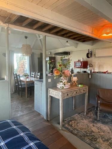 a kitchen with a table and a dining room at Holiday cottage de Garage Inn in Hank