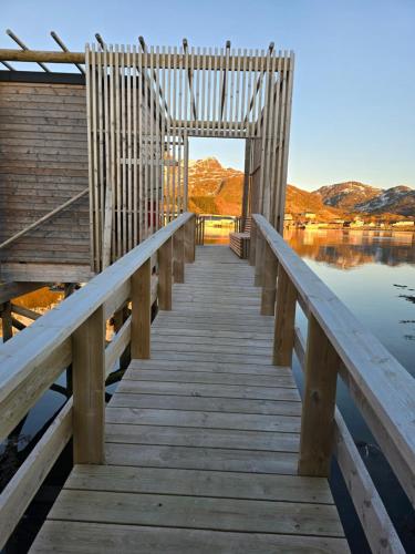 a wooden bridge over a body of water at Hemmingodden Lodge in Ballstad