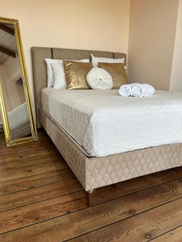 a bed with two pillows and a mirror in a bedroom at Le petit luxury apartment in Preveza