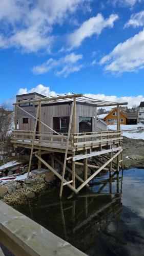 a house on a wooden dock on the water at Hemmingodden Lodge in Ballstad