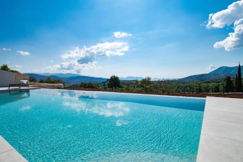 a swimming pool with a view of the mountains at Pentacle Villas in Lefkada Town
