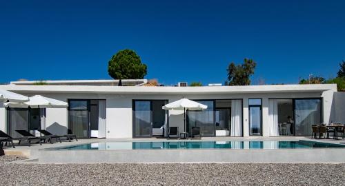 a house with a swimming pool in front of it at Pentacle Villas in Lefkada Town