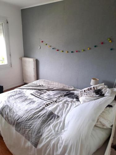 a bedroom with a white bed with a flag on the wall at 140 m2 , 3 lits 2 place et 1 canapé convertible 2 place in Lanvaudan