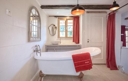 a white bath tub in a bathroom with a window at Kellestoeckl Moschendorf in Moschendorf
