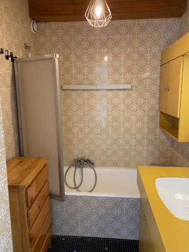 une salle de bain avec une baignoire et un lavabo dans l'établissement Majestic I, à Huez