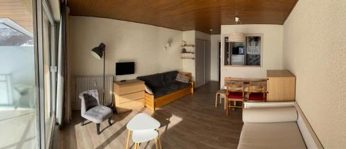 un salon avec un canapé et une table dans l'établissement Majestic I, à Huez