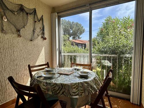 - une table dans une chambre avec une grande fenêtre dans l'établissement Appartement Studio cabine ARGELES SUR MER AR020-033, à Argelès-sur-Mer