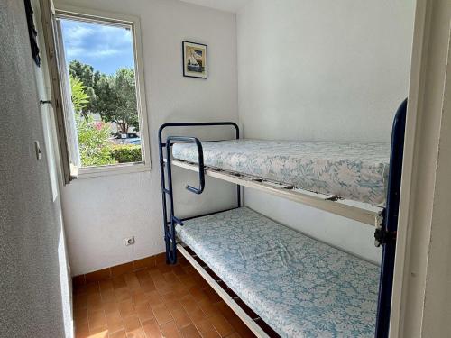 une chambre avec deux lits superposés et une fenêtre dans l'établissement Appartement Studio cabine ARGELES SUR MER AR020-033, à Argelès-sur-Mer