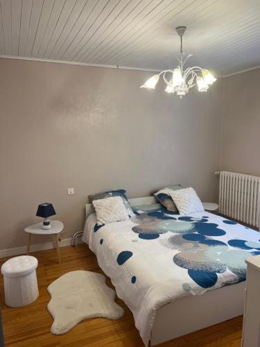 une chambre avec un lit et un lustre dans l'établissement Corps de ferme à 50min de Lyon, à Moissieu-sur-Dolon